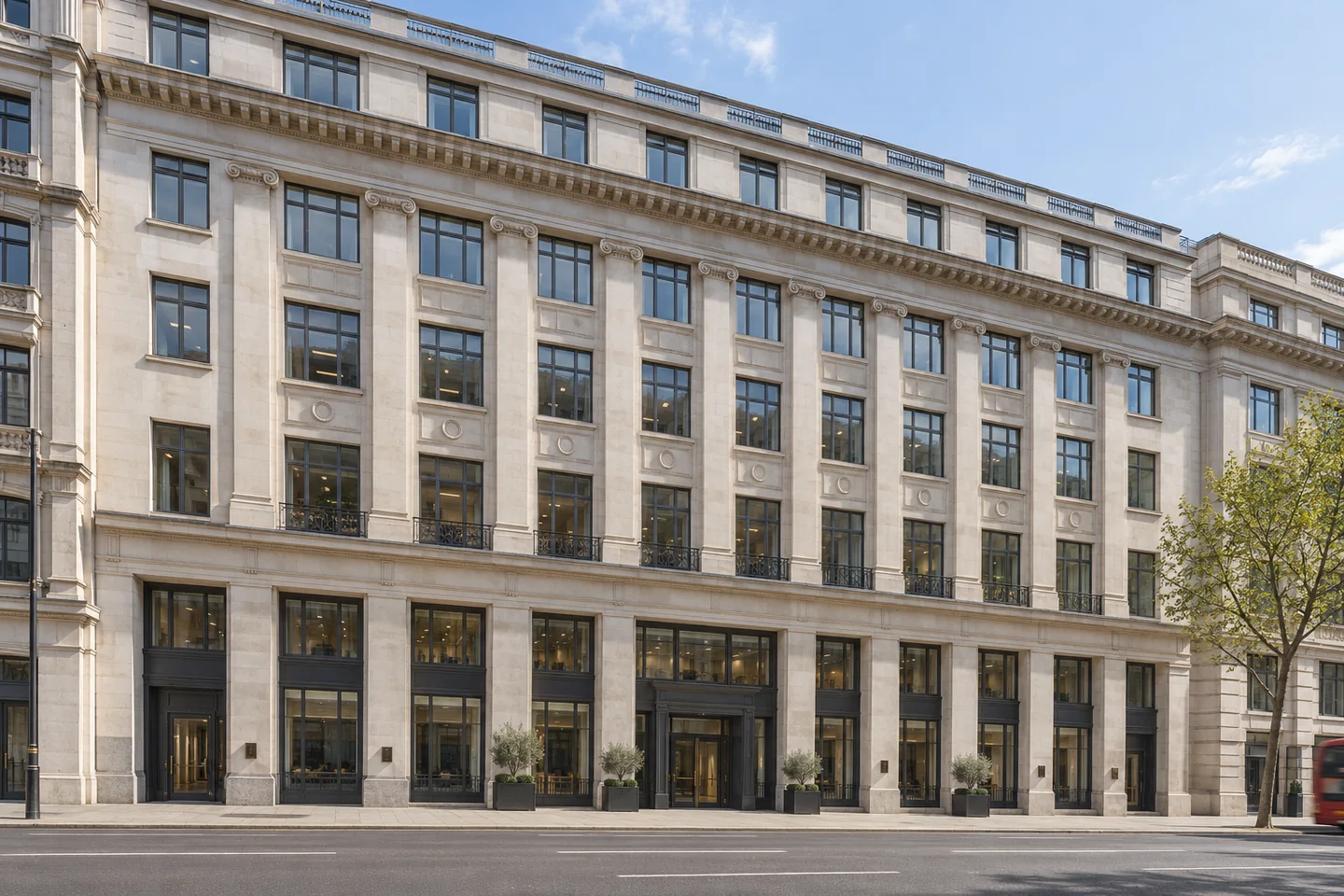Edwardian Portland stone office frontage with tall windows beside a broad central London street